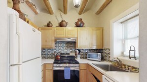 Una cucina compatta con mobili in legno, un fornello, un forno e un lavello.