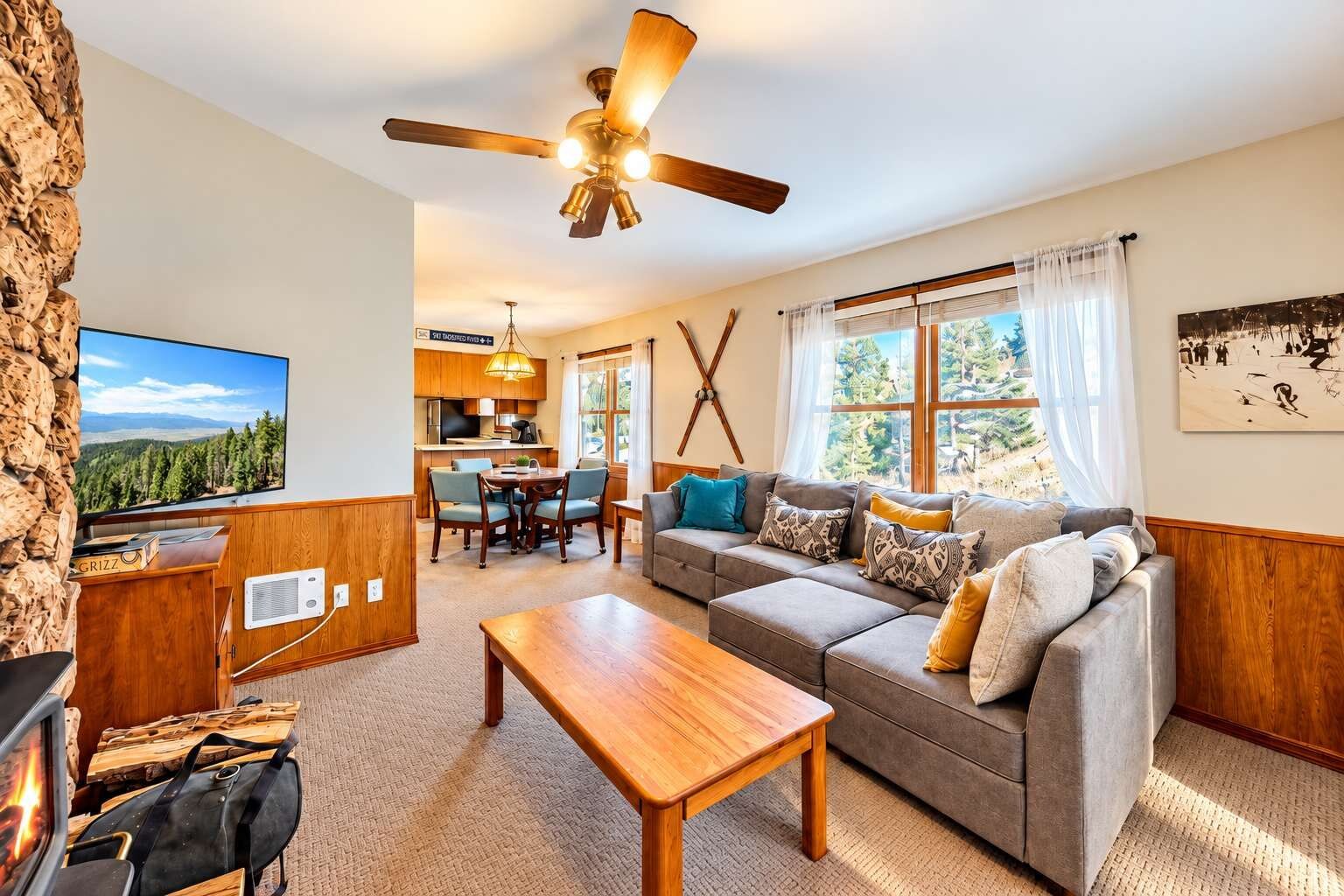 A living room with a sofa, a wooden coffee table, a television, and a fireplace.