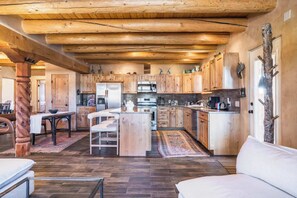 A spacious kitchen with wooden cabinets, a central island, and a dining area with a table and chairs.