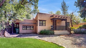 A single-story building with a flat roof, a front porch, and a small staircase leading to the entrance. - Casa Raya Taos - Mountain Views, Yard & Near Plaza (Taos)