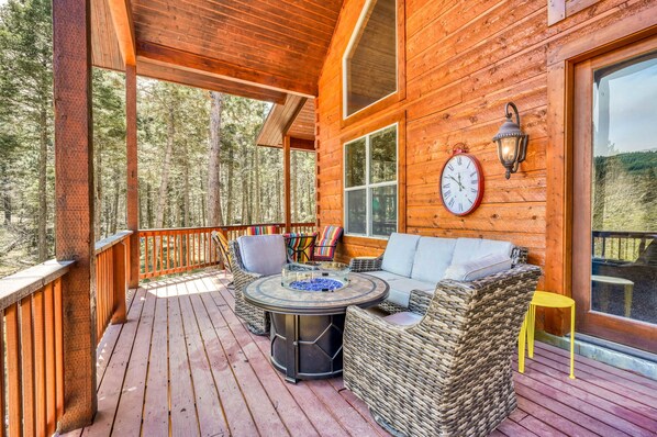 Eine Holzterrasse mit Gartenmöbeln, einer Uhr und einer Laterne.