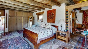 Une chambre à coucher traditionnelle en bois, avec un lit, des tables de chevet et des tapis.