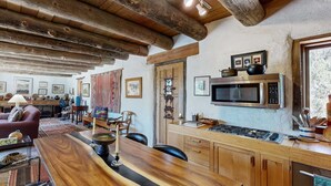 Une cuisine rustique avec des poutres en bois, un bar en bois et un four à micro-ondes.
