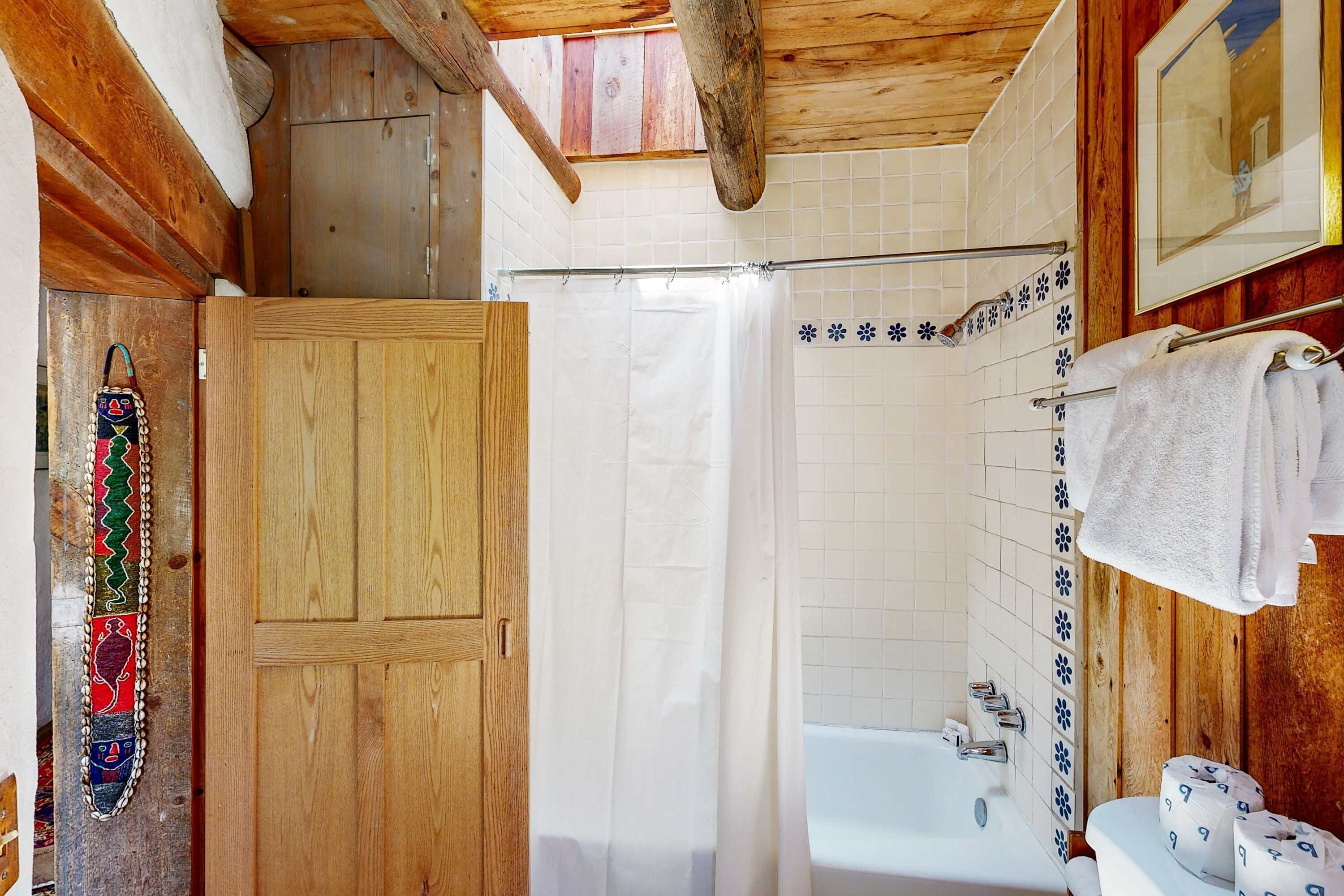 A wooden bathroom with a shower curtain, a bathtub, and a toilet.