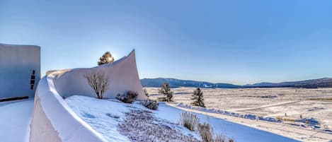 A snow-covered landscape with a unique curved building structure.