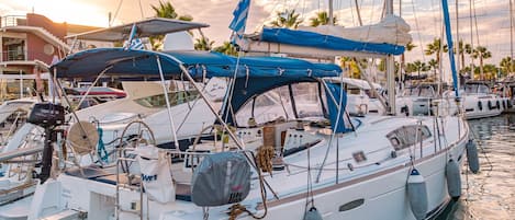 Un port de plaisance où sont amarrés de nombreux voiliers, avec leurs mâts, leurs voiles et divers équipements nautiques.