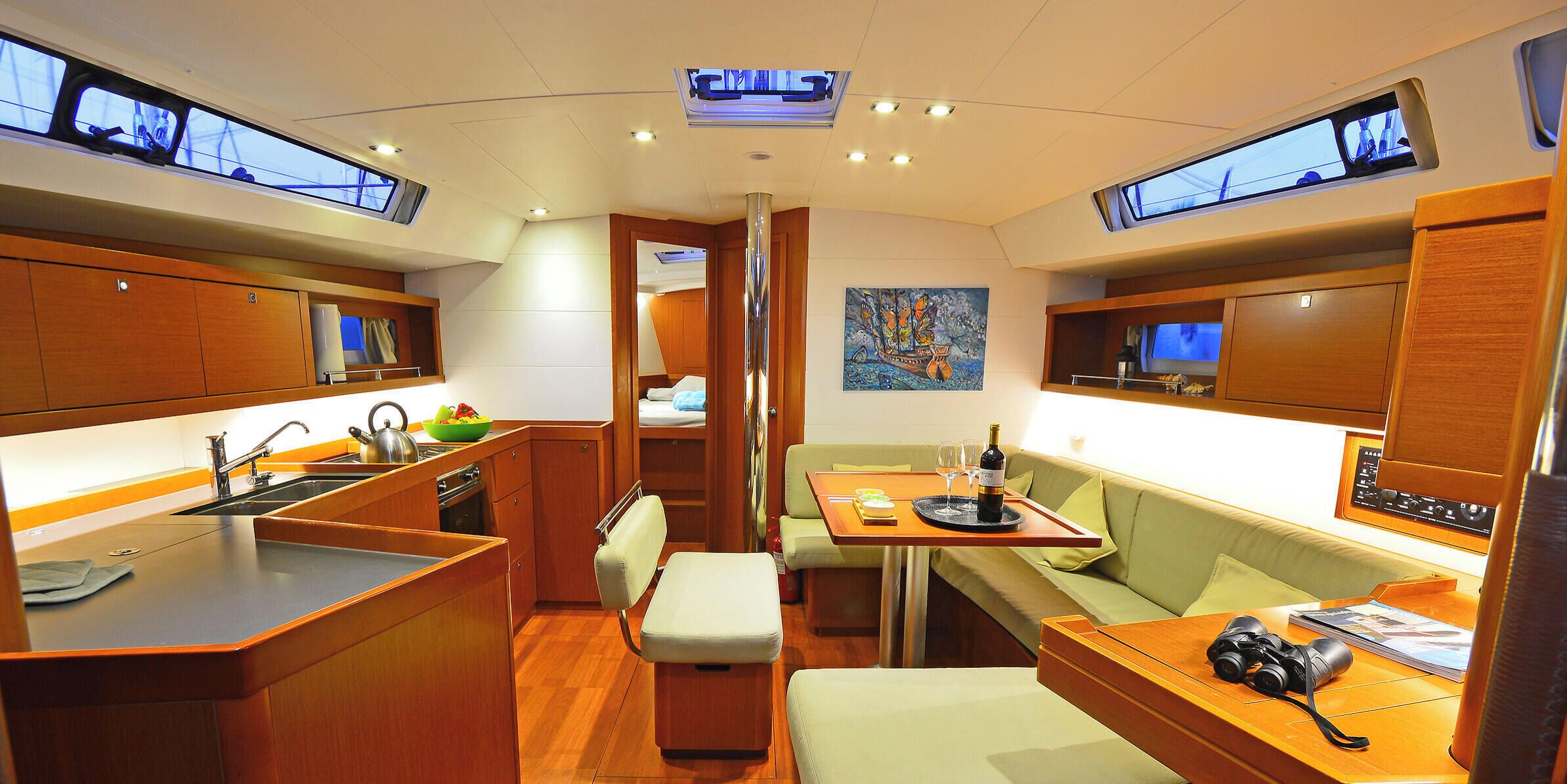 A compact kitchen with a sink, stove, and dining area with a table and seating.