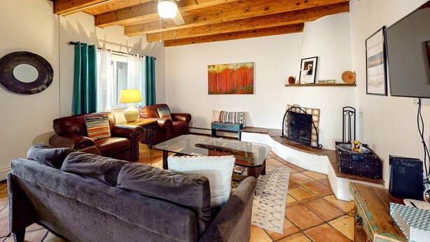 A living room with a sofa, armchair, coffee table, and fireplace. - Kathryn Place Casita - Walk to Downtown & Railyard (Santa Fe)