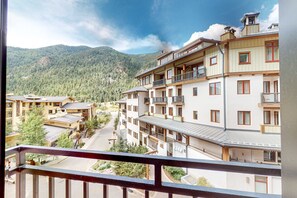 A multi-story hotel with balconies, a mountain backdrop, and a clear sky. - Majestic Alpine Retreat - Walk to Lifts & Town (Taos Ski Valley)