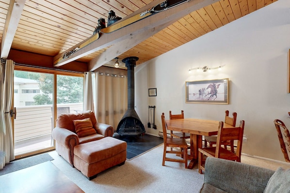 Ein gemütliches Wohnzimmer mit Kamin, Holzmöbeln und einem großen Fenster.