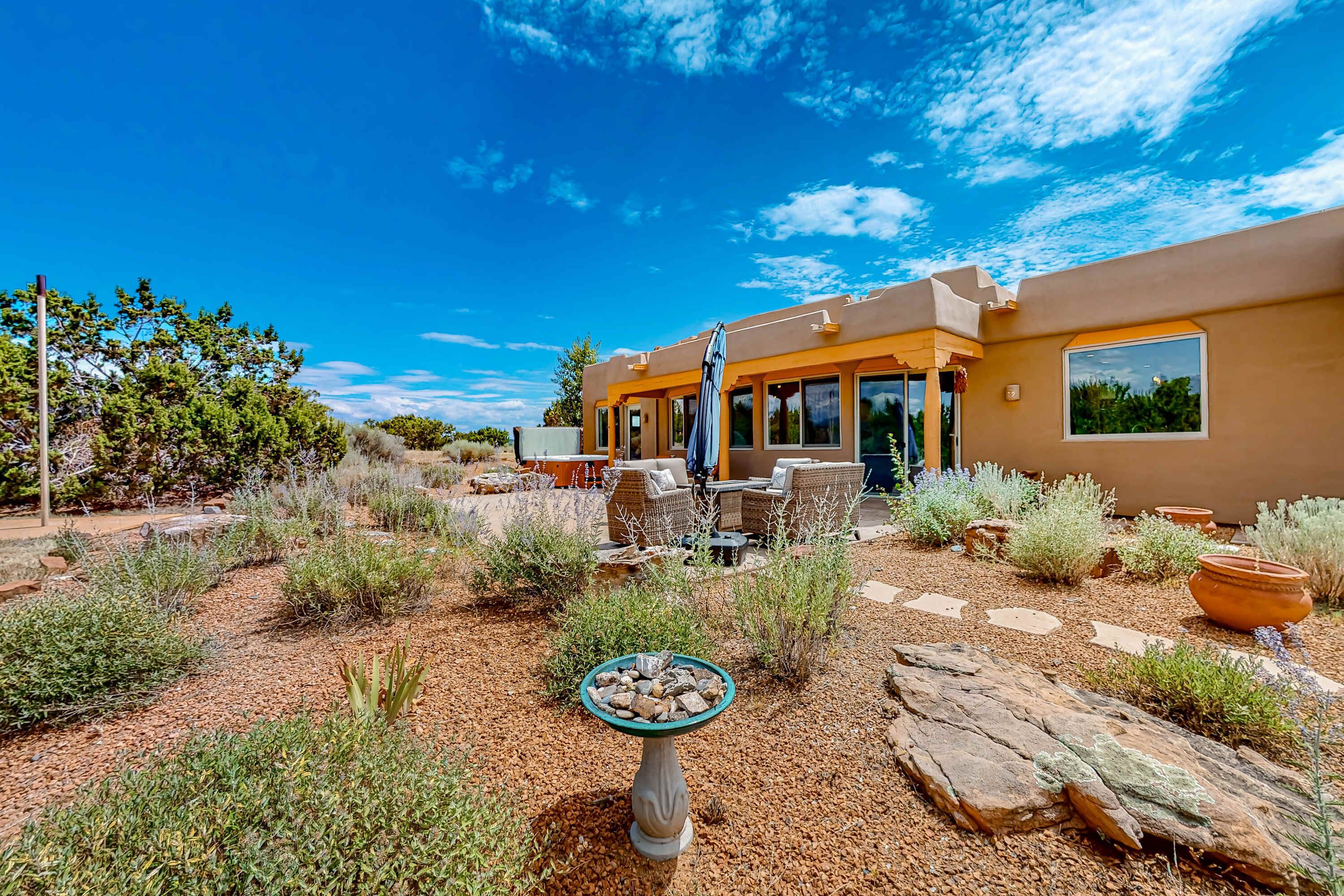 A modern house with a patio, outdoor furniture, and a bird bath.