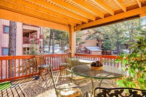 A covered outdoor area with a table, chairs, and a railing. - Outdoor Hideout - Walk to Ski, Hike, Bike & Dining (Angel Fire)