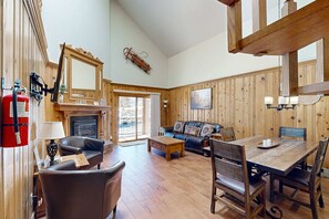 A wooden interior with a fireplace, leather furniture, a dining table, and a fire extinguisher. - Snowfire 308A - Views & Walk or Shuttle to Lifts (Angel Fire)