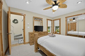 A bedroom with a bed, wooden dresser, television, and a ceiling fan. - Mystic Lodge • Ski Jack Frost + Lake Club Access (Lake Harmony)