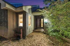 Una casa moderna amb un porxo cobert, una banca i un camí que condueix a l'entrada.