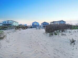 Een zandstrand met huizen aan het strand.