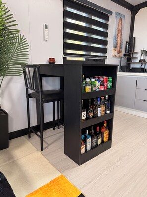 A modern kitchen with a built-in bar area, featuring a variety of liquor bottles and a coffee machine. - Beautiful 2-Bedroom modular home in the tranquil country side of Jobos Isabela. (Isabela)