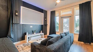 Ein modernes Wohnzimmer mit Sofa, Couchtisch und Flachbildfernseher.