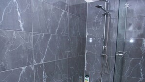 A modern bathroom with a bathtub, shower, and glass enclosure. - Modern 1 Bedroom Apartment in Quiet Tilbury Town (Tilbury)