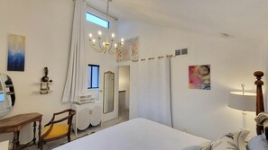 A hotel room with a bed, a chair, a desk, a mirror, a chandelier, and artwork on the walls. - 3-bedroom/ 2 bath fully designer-remodeled house in central Albuquerque, by UNM (Albuquerque)