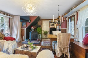 A cozy living room with a fireplace, a chandelier, and a comfortable seating area. - Mount Snow Lake Whitingham Antique Apartment in Jacksonville-Whitingham Vermont (Whitingham)