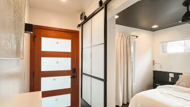 A bedroom with a bed, a sliding door, a window, and a door with frosted glass panels. - Boutique 1BR Private Unit with AC, Silicon Valley, 5 min Santana Row, fast WiFi (San Jose)