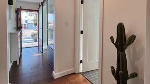 A hallway with a wooden floor, a glass door, and a cactus plant. - Boutique 1BR Private Unit with AC, Silicon Valley, 5 min Santana Row, fast WiFi (San Jose)