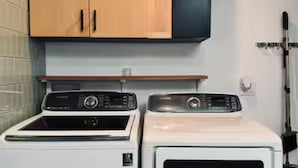 A laundry area with two stacked washers and dryers, wooden cabinets above, and a tiled backsplash. - Boutique 1BR Private Unit with AC, Silicon Valley, 5 min Santana Row, fast WiFi (San Jose)