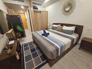A hotel room with a bed, a desk with a computer, a TV, and a potted plant. - Studio near bech ans 5thAv. All you need to enjoy Playa del Carmen (Playa del Carmen)