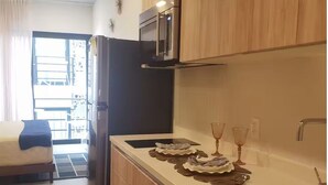 Eine moderne Küche mit Holzausstattung, einer Mikrowelle und einem Essbereich mit Bett und Aussicht.