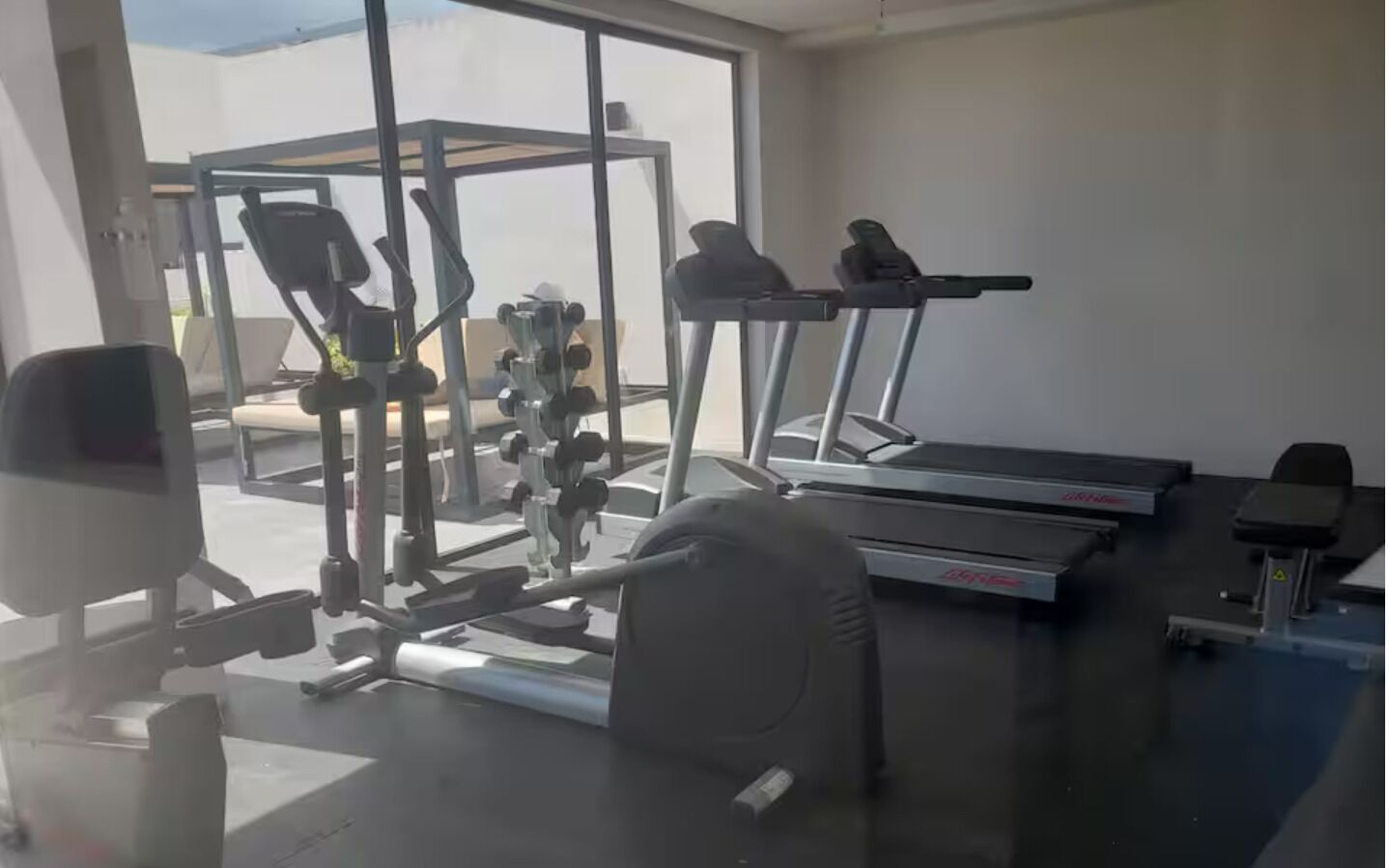 A gym with exercise equipment, a treadmill, and a weight bench.
