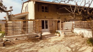 A rustic house with a gravel driveway, wooden fences, and a small garden area. - Villa Sainte Anne whole house and Spa overlooking the Alpilles (Sénas)