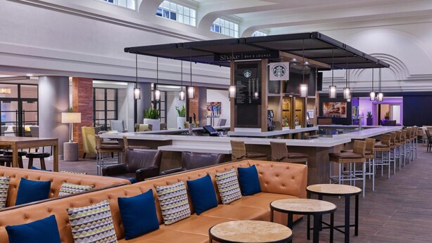 A spacious bar/lounge area with seating, a bar counter, and a Starbucks sign. - Sleek City-View King Suite Near San Diego’s Best Food & Nightlife (San Diego)