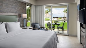 Ein Hotelzimmer mit Bett, Schreibtisch, Stuhl, Fernseher und einem Balkon mit Blick.