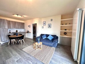 Una sala de estar moderna con sofá, mesa de centro y comedor.