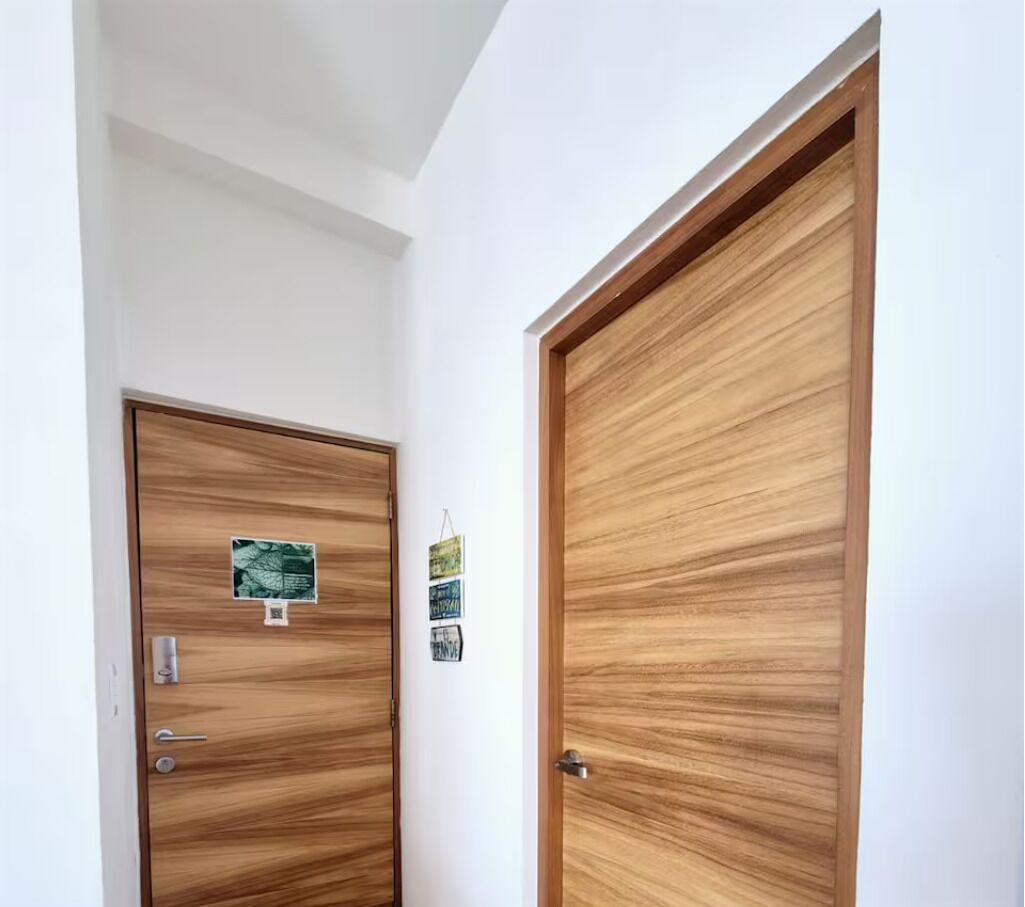 Deux portes en bois, un mur blanc et un plafond.