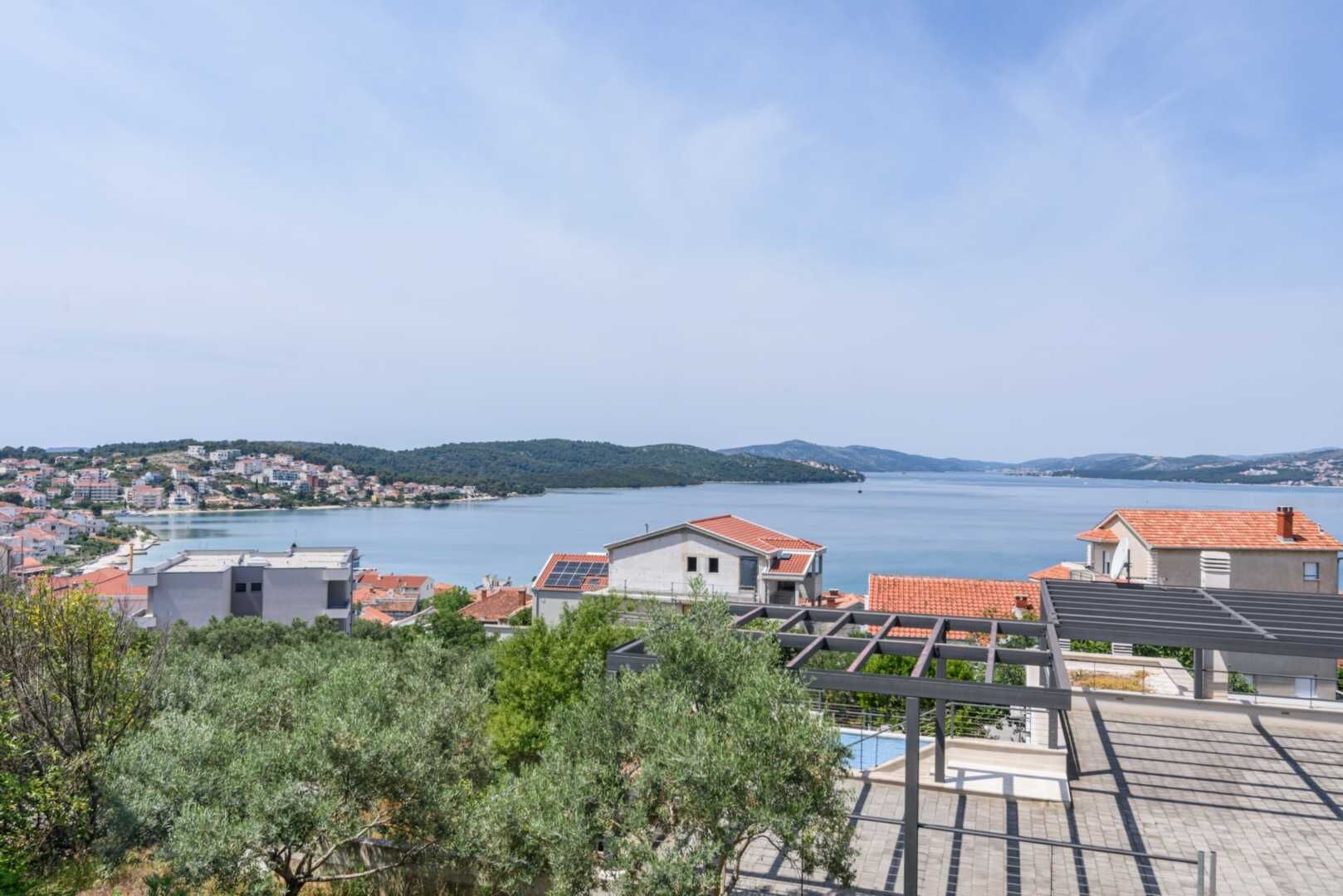 A coastal town with buildings, a clear sky, and a view of the sea.