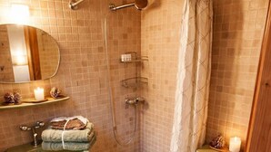 Une salle de bain équipée d’une douche, de toilettes, d’un lavabo et d’un miroir.
