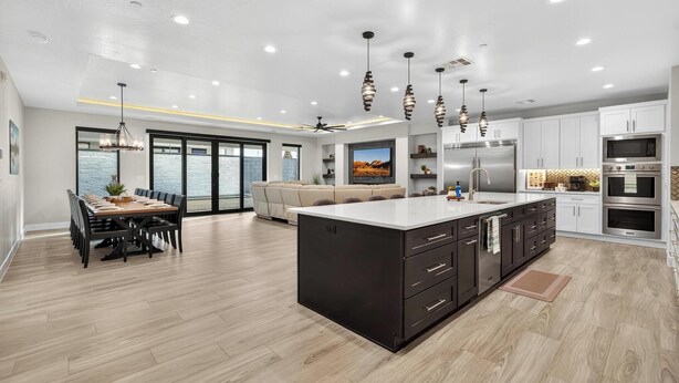 Una cocina moderna con una isla grande, electrodomésticos integrados y un comedor con vistas.