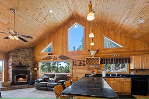 Eine geräumige Hütte mit einem großen Essbereich, einem Kamin und einer Küche.