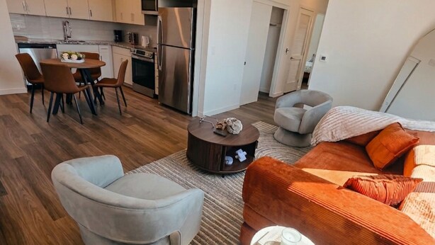 A modern apartment with a dining area, kitchen, and living room.