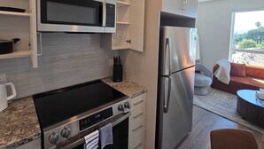 A modern kitchen with stainless steel appliances, a built-in oven, and a microwave.