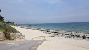 A beach with a paved walkway, a stone wall, and a view of the sea. - Stunning vacation villa in Carnac Plage (Carnac)