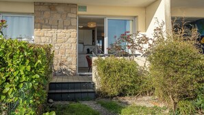 A residential building with a stone facade, a visible entrance, and a small porch area. - Sea-view garden-level flat (Ploemeur)