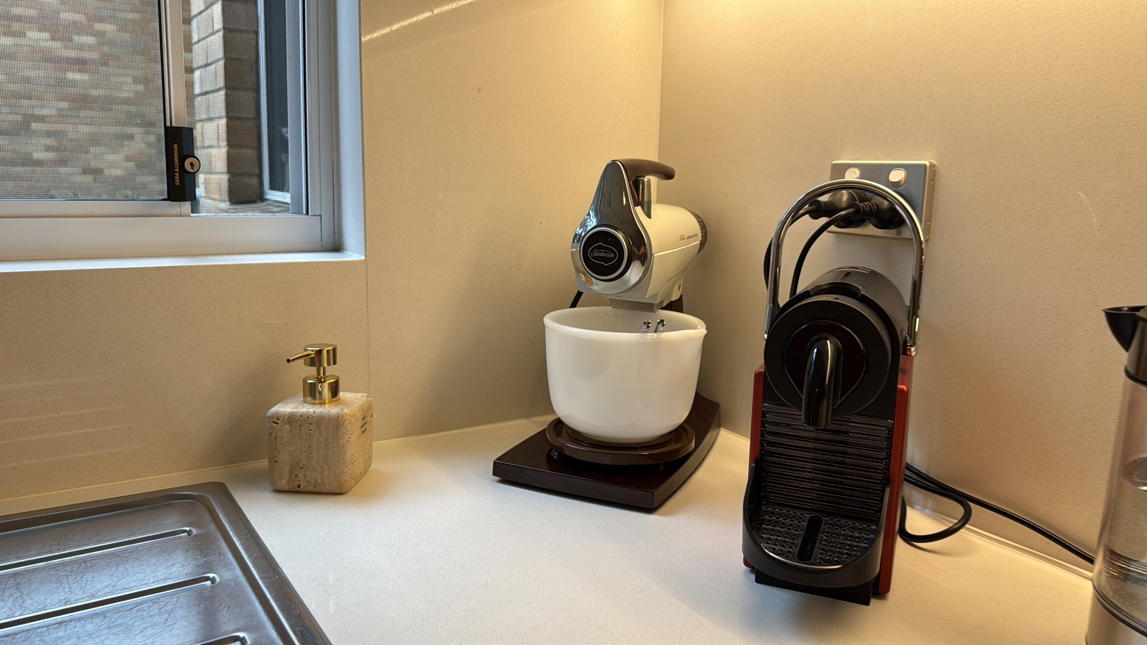 Ett kök med en kaffebryggare, en vattenautomat och en diskho.
