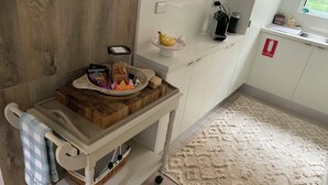 Una cucina con un tagliere di legno, un cesto e un piccolo tavolo.