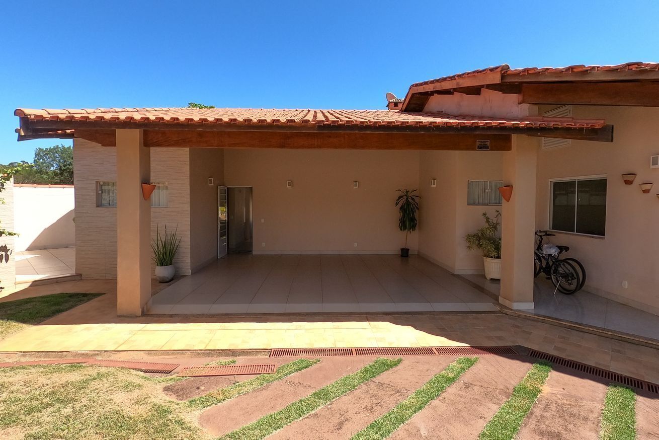 Uma casa com varanda coberta, garagem e uma bicicleta estacionada na frente.