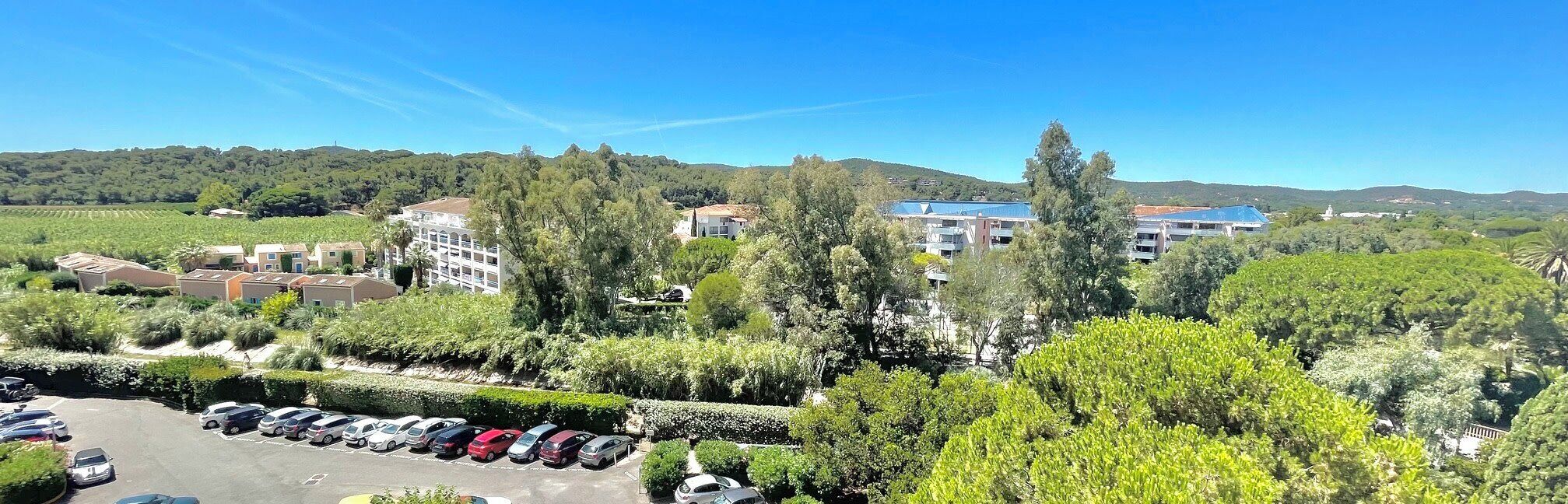 Zona residencial con varios edificios, un estacionamiento y zonas verdes circundantes.