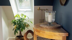 A wooden table with a glass vase, a woven placemat, and a potted plant. - Riverside living, reimagined above the Teifi (Cardigan)