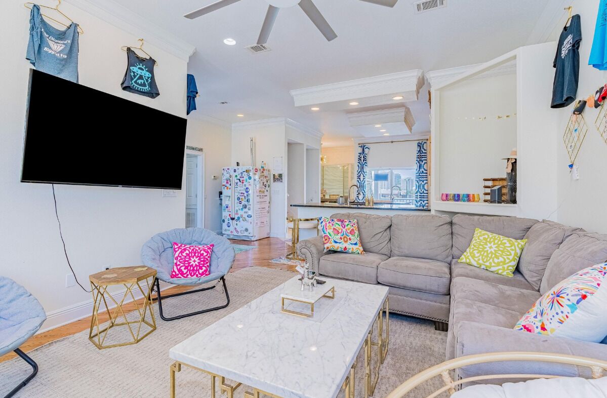 A modern living room with a flat-screen TV, a sofa, a coffee table, and a chair.